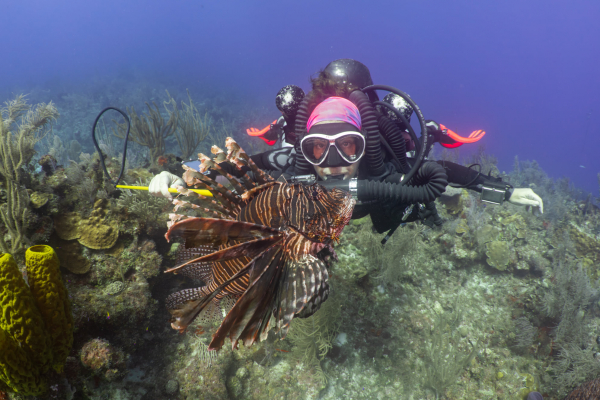 Diver with red lionfish underwater